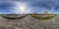 a fish eye lens of a person riding on a skateboard down a road in front of buildings