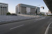 a car drives down a road next to a tall building with a freeway below it