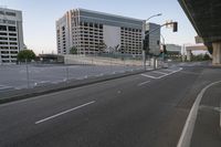 a car drives down a road next to a tall building with a freeway below it