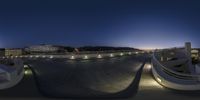 view of a skateboard park with a night sky behind it and the sun low lighting on it