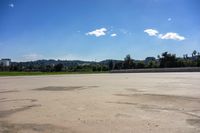 the sun shines brightly on an empty parking lot with an open field behind it