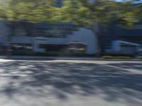 a man is skateboarding along the street with his skateboard in front of him