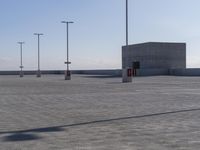 parking lot with multiple lights and street signs in empty setting on flat surface under clear skies