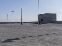 parking lot with multiple lights and street signs in empty setting on flat surface under clear skies