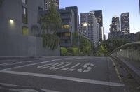 a city street with buildings in the distance and an empty parking space with a white sign on it