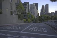 a city street with buildings in the distance and an empty parking space with a white sign on it