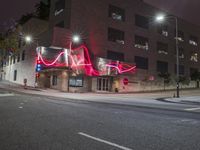 red lights that glow like an arrow on an intersection at night in a downtown area