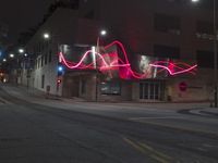 red lights that glow like an arrow on an intersection at night in a downtown area