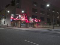 red lights that glow like an arrow on an intersection at night in a downtown area