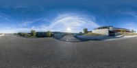 a 360 - angle view of the road and the house in the distance has a circular structure with small, dark areas