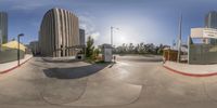 a mirror showing two buildings with sun in the background and one has his skateboard on the pavement and the other side