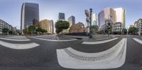 a city street with an artistic circular shaped intersection and some buildings in the background on a sunny day