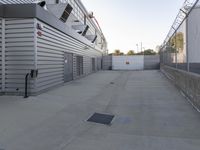 a parking lot with a closed up storage compartment and a gate in the center with a sky in the background