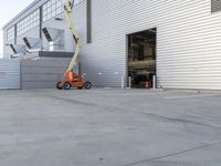 a man using a crane to lift a building from inside a storage unit into place