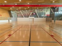 an indoor gym with sports court and red stripe floors from the ground level of a building