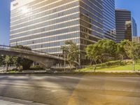 a big office building and a bridge in the middle of a city intersection on a clear day