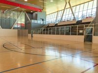 the interior of a sports hall with basketball seats on the floor and lights hanging overhead