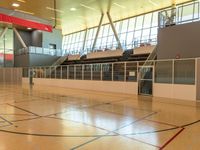 the interior of a sports hall with basketball seats on the floor and lights hanging overhead