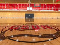 a very nice gym floor with a few numbers on it on the wall and a logo on the wall