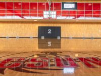 a very nice gym floor with a few numbers on it on the wall and a logo on the wall