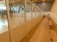 an empty basketball court with a bench near by the benches and wall partitions from the indoor court