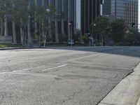 a person walking down a deserted city street with skyscrapers in the background in the daytime