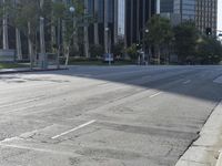 a person walking down a deserted city street with skyscrapers in the background in the daytime