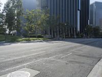 a person walking down a deserted city street with skyscrapers in the background in the daytime