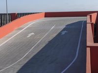 two skateboards parked on a long concrete road with a ramp in the distance and in the foreground