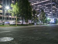 the street is lined with cars and tall buildings near each other at night time,