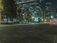 the street is lined with cars and tall buildings near each other at night time,