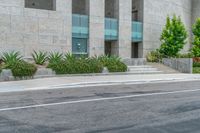 a white motorcycle is parked near the curb near a building with steps and plants on one side