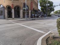 the pedestrians are waiting at the green traffic light to cross the street from the shops