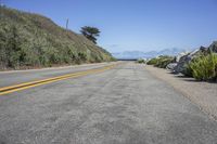 a lonely road along a hill that is by the ocean shore line in california, usa