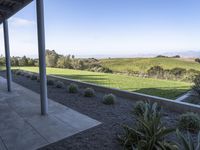 view of rolling green hills from outdoor deck in desert area of winery estate patio and covered patio with blue sky