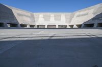 a road has concrete overpass and cement wall with cement under bridge area in background