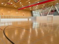 a gymnasium that is made out of wood and with a basketball court inside the center