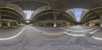 there is a fisheye effect of a street with traffic lanes and road signs at the intersection