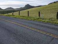 a highway is lined by two yellow double line lines while mountains stand in the distance