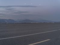 an airport has some mountains in the background on the airfield runway in the foreground