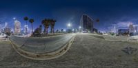 a 360 view of a city lit up at night with the lights on and an empty street next to it