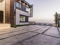 the exterior and landscape of a modern house in los angeles, california with stone and wood