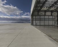 the empty building of an airport has only one car parked outside it to the right