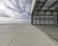 the empty building of an airport has only one car parked outside it to the right