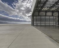 the empty building of an airport has only one car parked outside it to the right