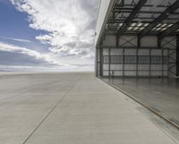 the empty building of an airport has only one car parked outside it to the right