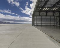 the empty building of an airport has only one car parked outside it to the right