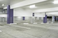 a parking garage with multiple floor and white walls and ceilings and purple beams and a painted ceiling