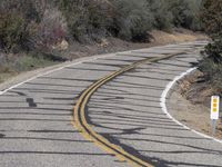 a person on a motorcycle is riding on the road down the road that has two yellow lines