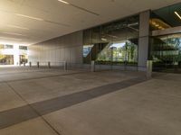 a long hallway in an office building with glass doors and no people inside of it